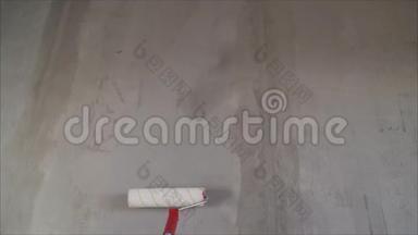 用滚筒将底漆涂在墙上的过程。 底漆溶液用滚筒涂在墙上，以便重新加工