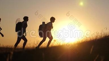 旅游团队合作。旅行者孩子和妈妈背着背包在美丽的阳光下爬山