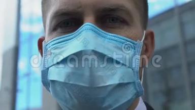 戴着面具的严肃男人看着镜头，担心城市空气污染