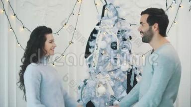 一对相爱的夫妇在<strong>除夕</strong>夜`圣诞树附近见面，接吻，抚摸额头，互相牵着手。