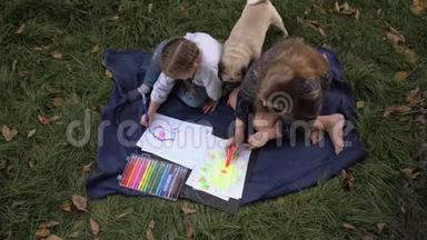 两个小女孩坐在公园的草地上，用<strong>铅笔</strong>在笔记本上<strong>画画</strong>，孩子们用彩色颜料<strong>画画</strong>