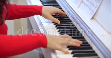 女或女学生或职业钢琴家在一架漂亮的白色钢琴上演奏古典音乐，钢琴家的手