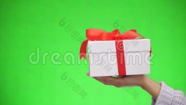 白色礼品盒用红色丝带蝴蝶结系在绿色背景上是孤立的。 最美好的祝愿。 快关门。 复制空间。