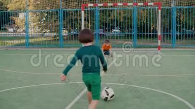 两个学童在<strong>学校操场</strong>上踢足球
