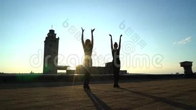 日落时分在屋顶表演的舞蹈二人组合剪影