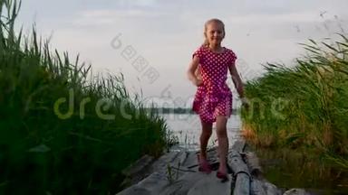 快乐的小女孩在湖边木板上的芦苇丛之间奔跑