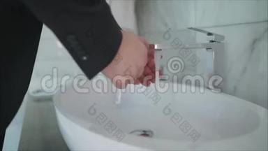 预防冠状病毒。 一个人在水槽里彻底洗手。 一个人把液体肥皂倒进他的手里。 从水中涌出