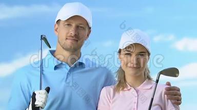 微笑的两个高尔夫球手与球杆对蓝天，高尔夫球杆教练