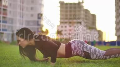 运动型美女做俯卧撑是她交叉健身、健身城市公园训练的一部分