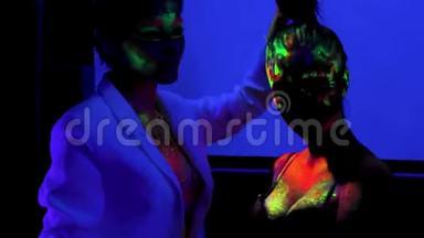 两个女孩的荧光化妆，身体艺术设计在紫外线，彩绘彩色脸