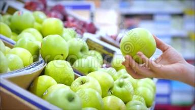 女人们在超市里买食物、水果、苹果、西红柿、桔子。女孩选择产品