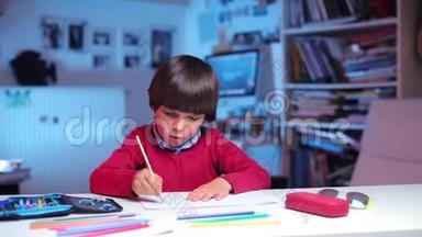 一个男孩坐在桌子旁，画一幅画