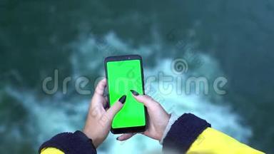 用智能手机<strong>拍摄</strong>黄色外套的年轻旅游女孩在<strong>瀑布</strong>自然移动生态旅游中的双手特写