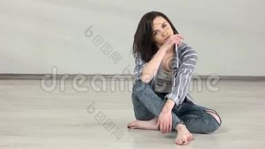 可爱的白种人女孩坐在舞蹈室的地板上。