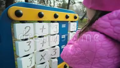 一个女学生在凉爽的天气在学校场地玩耍。 孩子解数学方程式，逻辑练习