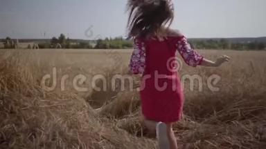 可爱的小女孩在田野里缓慢地奔跑。 在麦田里享受阳光的无忧无虑的女人。