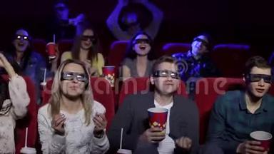 一个朋友在电影院戴着眼镜看3D电影，他们高高举起双手