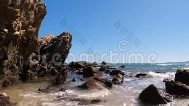 夏天，海浪海岸带着石头和岩石来到海滩