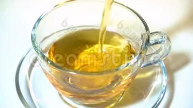 在白色背景特写镜头上，将茶壶中的红茶香气注入一个匹配的透明玻璃茶杯。