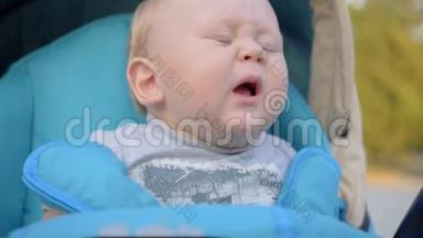 一岁的小男孩在婴儿车里打喷嚏。 特写镜头。 动作缓慢。