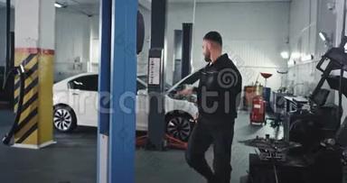 在摄像机前的机械师，一位现代<strong>服务</strong>的汽车人，检查汽车，在工作中跳舞，他很<strong>享</strong>受