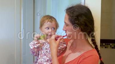 妈妈教孩子刷牙。 母女俩一起在卫生间刷牙.. 母亲和孩子的家庭