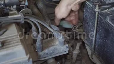 一个机械师<strong>正在修理</strong>汽车发动机上的东西