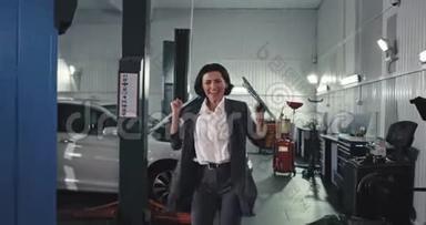 在汽车服务部门，快乐而有魅力的女员工在镜头前行走，在汽车服务部门感到非常兴奋