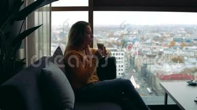 一位女士正在喝咖啡，看着<strong>窗外的</strong>城市<strong>景色</strong>