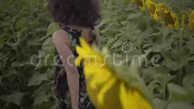 迷人的卷曲女人在向日葵的田野上<strong>奔跑</strong>。 明亮的黄色。 <strong>自由</strong>概念。 户外快乐的女人。 慢慢