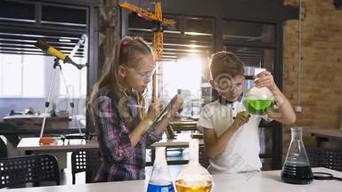 两名戴着安全护目镜的白种人小学生在烧瓶和干冰中试验绿色液体