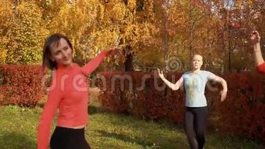 斯利姆女士在秋日在五颜六色的公园练习胸罩。 健身女子舞蹈班培训