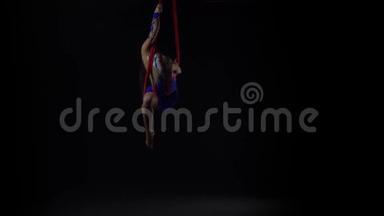 女空中体操运动员在黑色背景下表演红色丝绸。 精彩的杂技表演.. 慢动作。 139