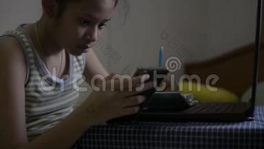 亚洲可爱的女孩穿着单身衬衫在网上看课，在床上做作业。 女青少年在家学习。