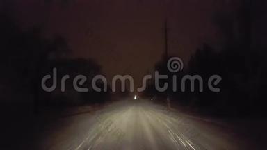 夜间在暴风雪中在农村公路上行驶。 司机的观点POV厚和大暴雨雪和雪花
