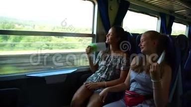 女孩们微笑着，用小册子作为扇子在火车上<strong>降温</strong>