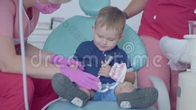 可爱的小男孩在<strong>牙医</strong>办公室玩着假牙。无忧无虑的儿童<strong>看病</strong>。牙科治疗