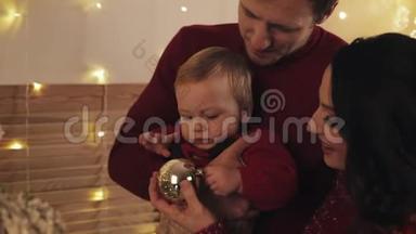 在家中，爸爸<strong>妈妈</strong>和小儿子站在圣诞树旁，<strong>宝宝</strong>和<strong>妈妈抱着</strong>
