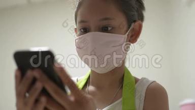 亚洲可爱的女孩穿着围裙，戴着防护面具，用手机与她的朋友进行社交在线交流。