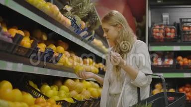 在<strong>杂货</strong>店手工挑选柠檬的妇女在<strong>超市</strong>的水果和蔬菜通道挑选柠檬。