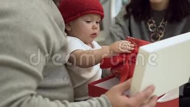 华丽的家庭与令人难以置信的可爱婴儿在筒子帽考虑圣诞礼物