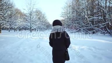 穿着暖和的夹克的女人从后面。 一个<strong>女孩</strong>在雪地里散步。 冬天的<strong>雪景</strong>。 森林里的雪堆