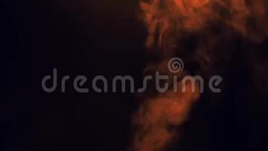 橙色蒸汽烟雾在黑色背景上喷出。 抽象背景的概念。