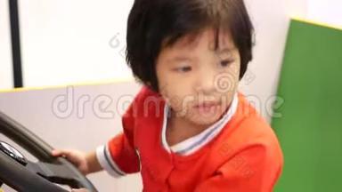 小亚洲女孩喜欢开一个街机<strong>汽</strong>车驾驶游戏，并邀请她的父母坐在她旁边