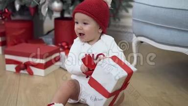 可爱的微笑<strong>宝宝</strong>穿着有趣的新年衣服，在圣诞树附近嬉戏，玩着美丽的<strong>礼</strong>物