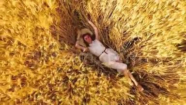 空中飞起的年轻女子躺在成熟的麦穗中的金色麦田里