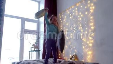 快乐的十几岁女孩在圣诞室内用大窗户玩跳床游戏。