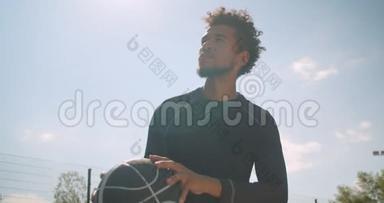 年轻有技能的非裔美国男篮球运动员在户外向篮筐投掷球的特写镜头