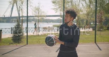 年轻英俊的非裔美国男篮球运动员向<strong>篮筐</strong>投掷一个球的<strong>特写</strong>侧景肖像