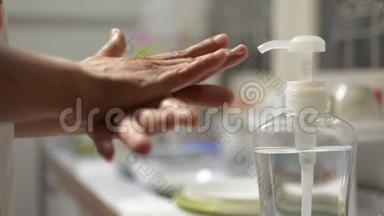 女人在COVID-19疫情期间用酒精凝胶洗手。 家庭主妇清洗厨房用具。